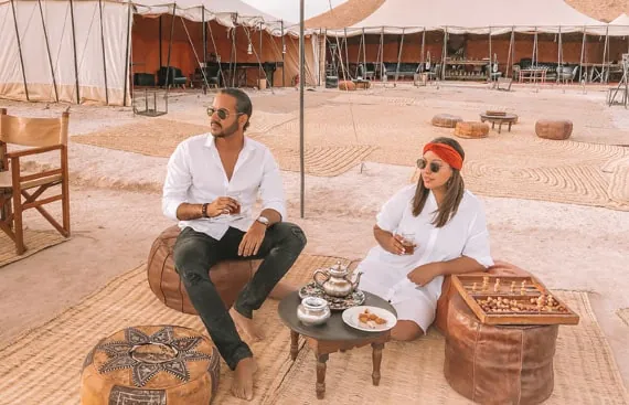 Désert d'Agafay depuis Marrakech au coucher de soleil — tentes caïdales et Atlas en arrière-plan
